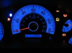 the dashboard of a car is lit up with blue lights and white gauges on it