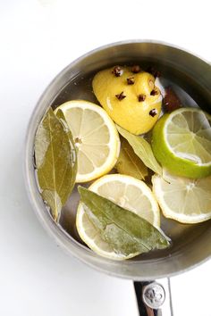 lemons, limes and leaves in a pot with water