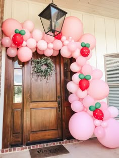 an entrance decorated with pink and green balloons