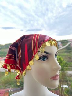 a mannequin wearing a red and gold head piece