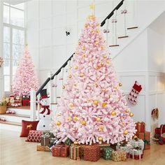 a pink christmas tree with presents under it