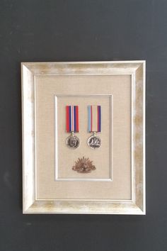 two medals are framed in a white frame