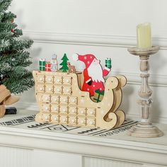 a wooden sleigh with santa claus on it next to a small christmas tree