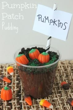 pumpkin patch pudding in a plastic cup with candy candies on the side and a sign that says pumpkin patch pudding