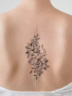 a woman's back tattoo with flowers and an elephant