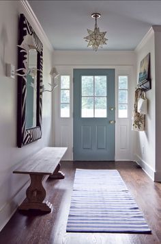 a hallway with a blue door and wooden bench