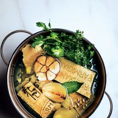 a metal bowl filled with different types of food