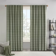 a living room with green plaid curtains and a white rug