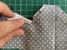 someone is cutting up the fabric on top of an origami style paper piece