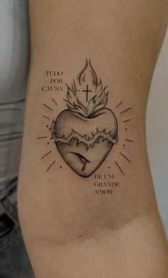 a tattoo on the back of a woman's stomach with an image of a heart and cross