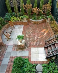 an aerial view of a courtyard with benches and plants in the foreground, surrounded by brick pavers