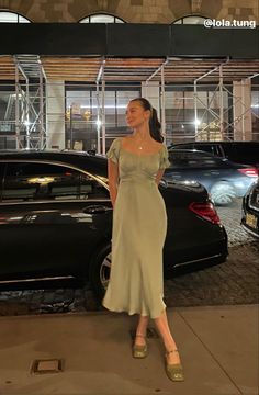 a woman is standing in front of some cars