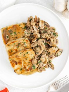 a white plate topped with fish covered in mushrooms