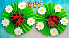 two paper fans with ladybugs and daisies on them, one is green