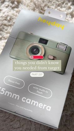 a camera sitting on top of a white carpet next to a box with the words, 5mm camera