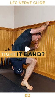 a man standing on top of a black mat in front of a wall with words that read tight it band?