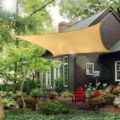 a house with a green awning over it's front yard and garden area