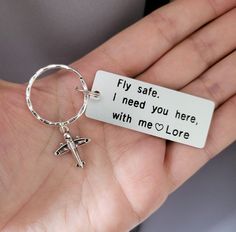 a person holding a keychain that says, fly safe i need you here with me love