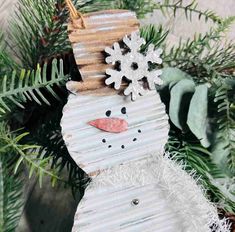 a paper snowman ornament hanging from a christmas tree