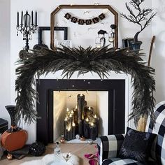 a living room decorated for halloween with black and white decorations on the fireplace mantel