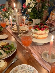 a table is set with food and candles for a dinner party or brunch