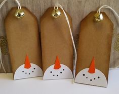 three brown paper bags with white and orange designs on them, one has a gold bell