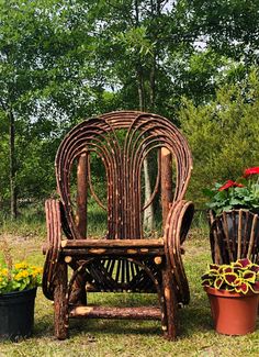 a wooden chair sitting in the grass next to some potted plants and flowers on top of it