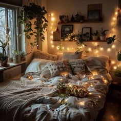 an unmade bed covered in blankets and lights