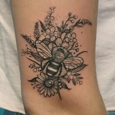 a black and white photo of a bee with flowers on it's back leg