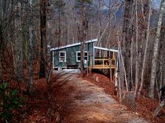 a small house in the woods near a dirt road