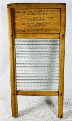 an old wooden sign sitting on top of a white tablecloth covered floor next to a wall