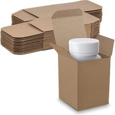 an open cardboard box with a white cup in it and stacks of brown boxes behind it