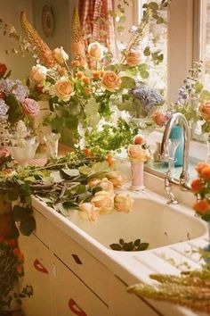 a kitchen sink with flowers on the counter top and in front of it is a window