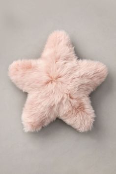 a pink star shaped plush toy on a gray surface