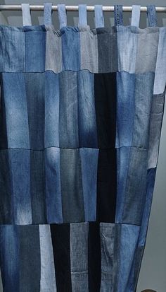 a blue and black patchwork curtain hanging from a metal rod in front of a radiator