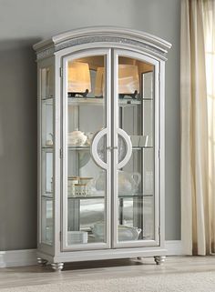 a white china cabinet with glass doors on the front and bottom, in a living room