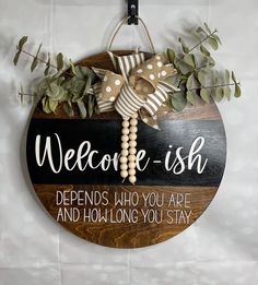 a wooden sign that says, welcome ish defends who you are and how long you stay