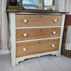 a dresser with three drawers and a mirror on top