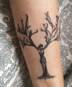 a woman's arm with a tattoo on it that has branches growing out of it