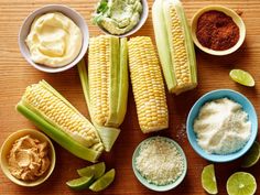 corn on the cob with spices and seasoning in bowls next to other ingredients