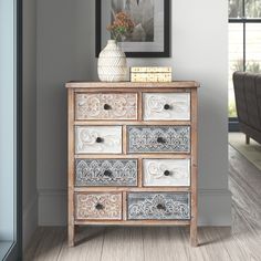 a white vase sitting on top of a wooden dresser