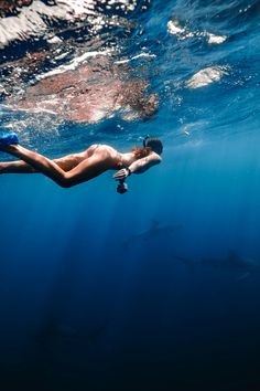 a man swimming in the ocean with his feet up and head above water's surface