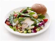 a white plate topped with salad and a roll