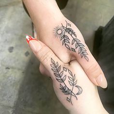 two people holding hands with tattoos on their fingers and the other hand has an arrow