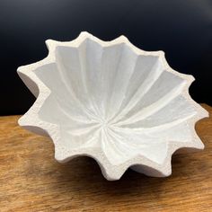 a white bowl sitting on top of a wooden table