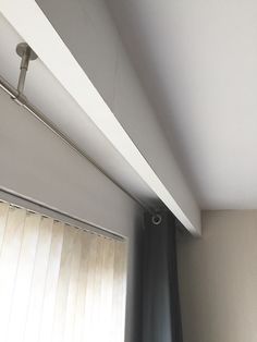 the corner of a room with a window and blinds