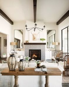 a living room filled with furniture and a fire place in front of a mirror on the wall