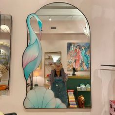 a woman taking a selfie in front of a mirror with a flamingo on it