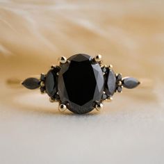 a black diamond ring with three stones on it