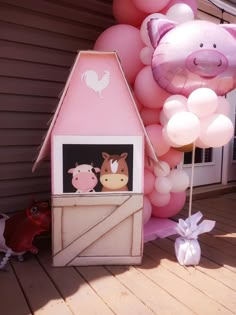 a pink house with balloons and farm animals on it